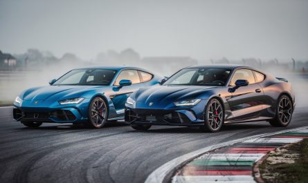 Deux compactes sportives premium vues de trois quarts avant sur un circuit, dans une ambiance de presse automobile avec une lumière naturelle.